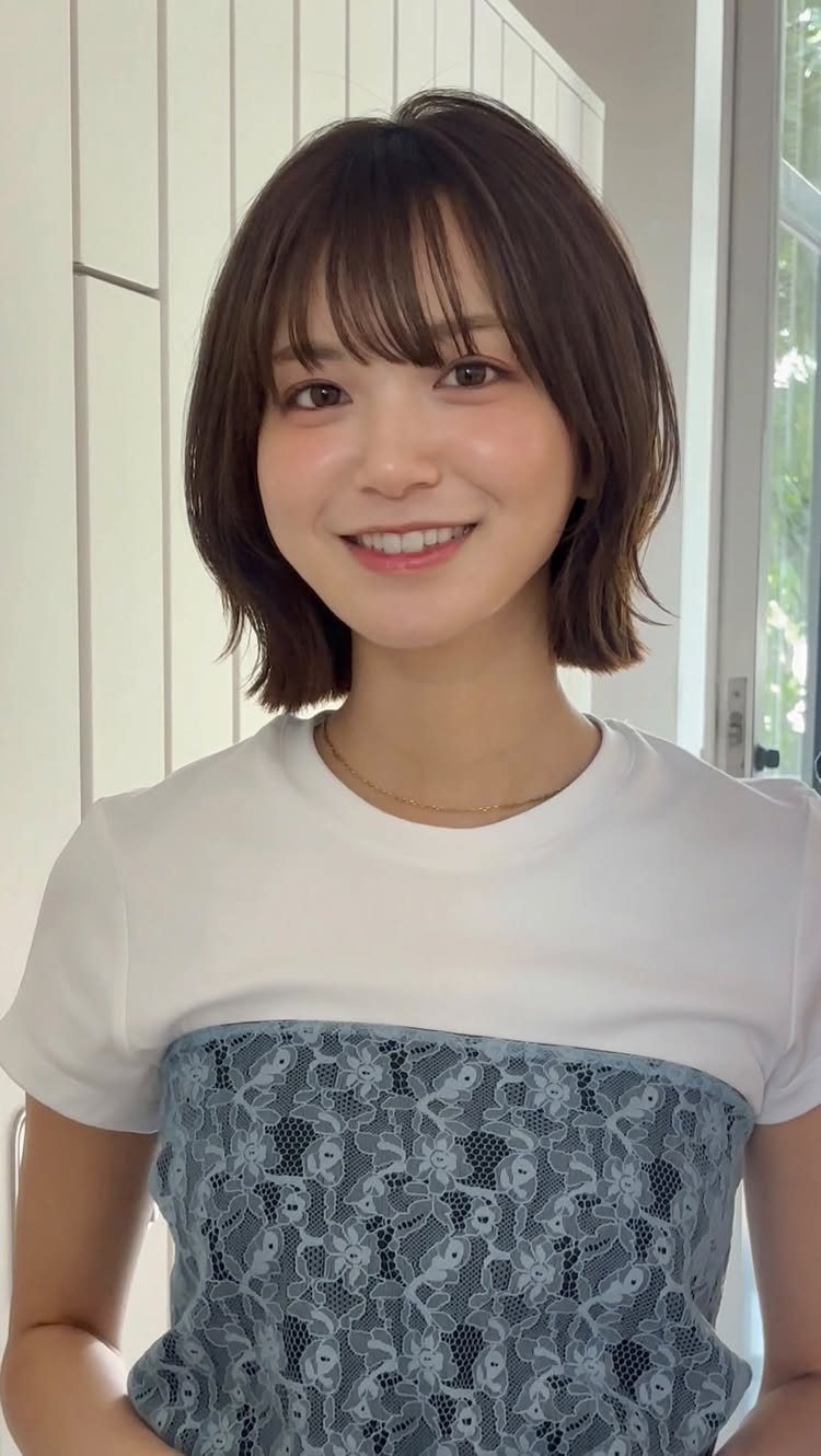 Woman with a dark layered bob, wispy bangs, and flipped-out ends