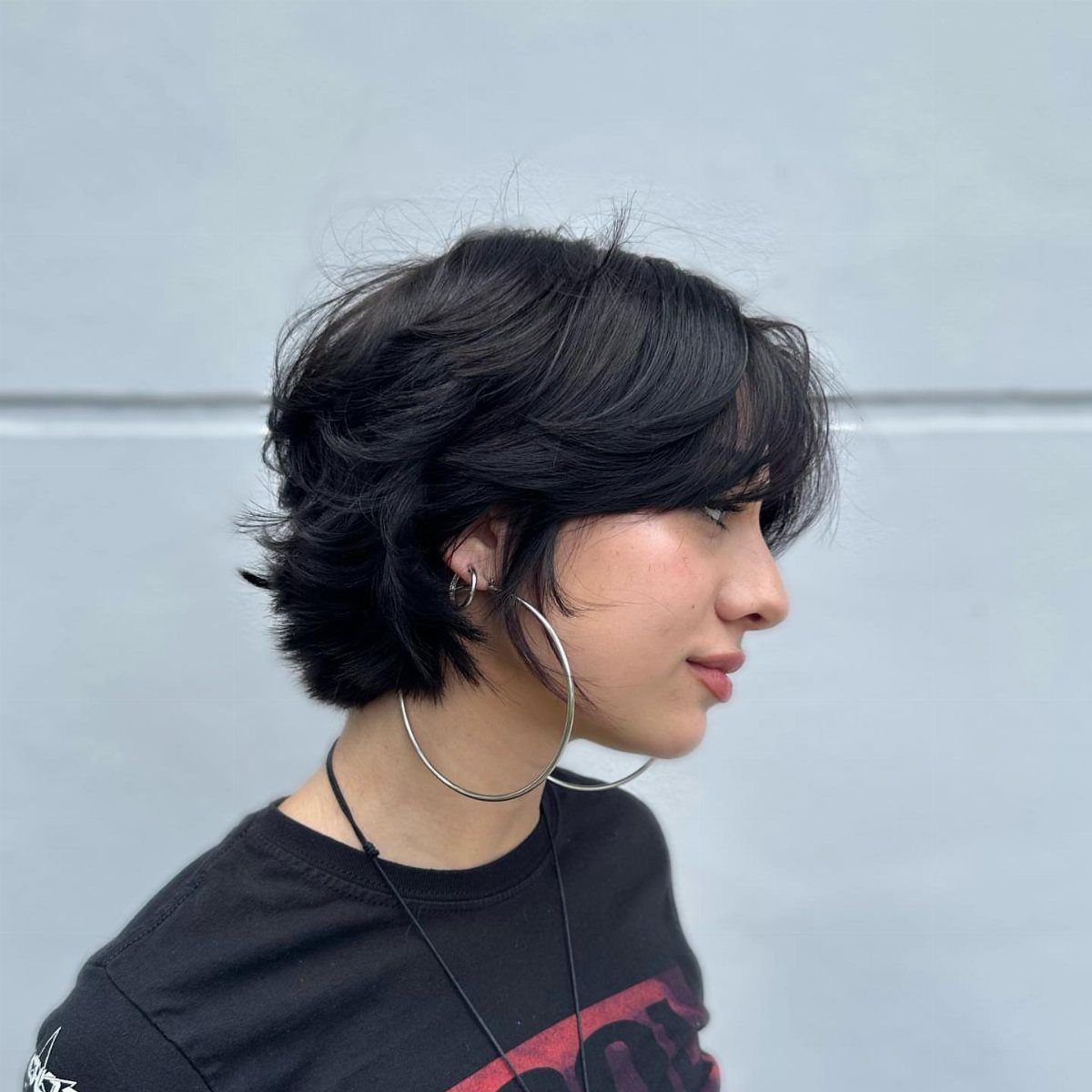Dark asymmetrical layered bixie with side-swept bangs and stacked back