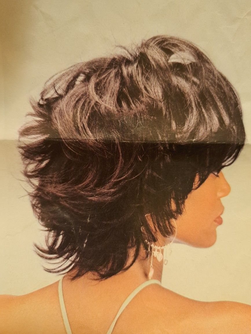 Woman showing a layered, jagged brown crop cut reaching her neck