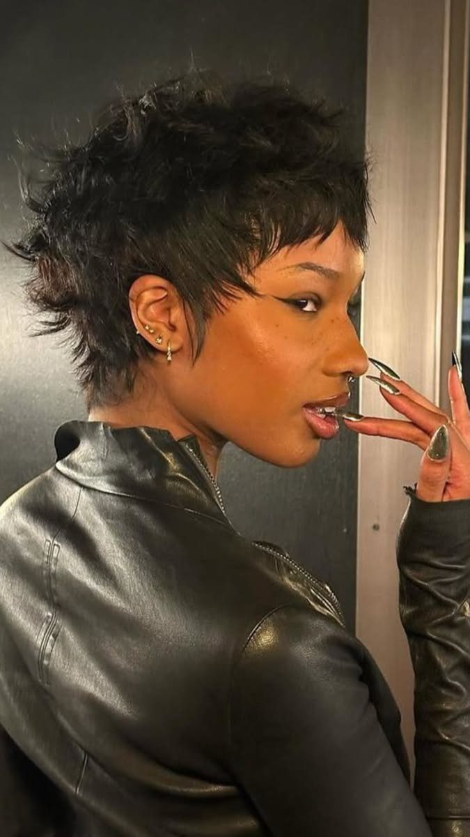 Person in profile showing short, dark tousled spiky hair with tapered sides