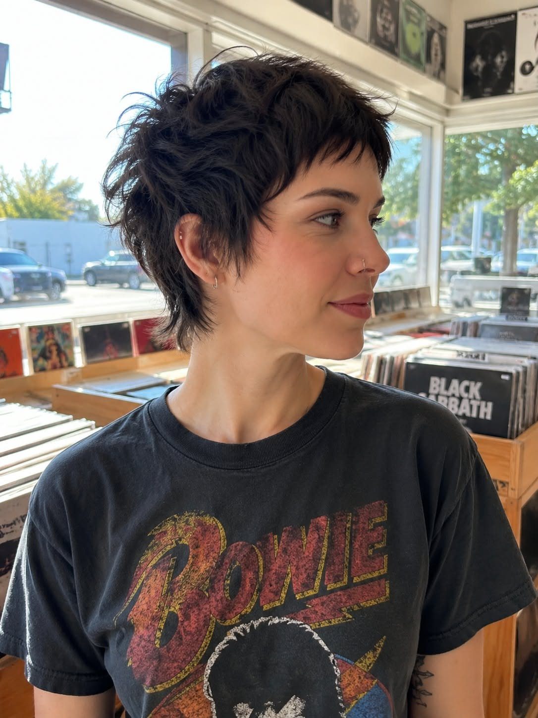 Woman showing a tousled dark pixie cut with short choppy bangs