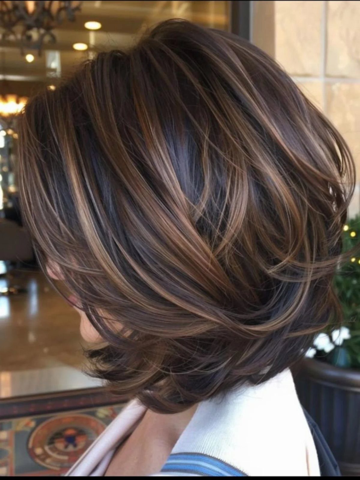 Warm brown bob with layered, curved ends and lighter highlights