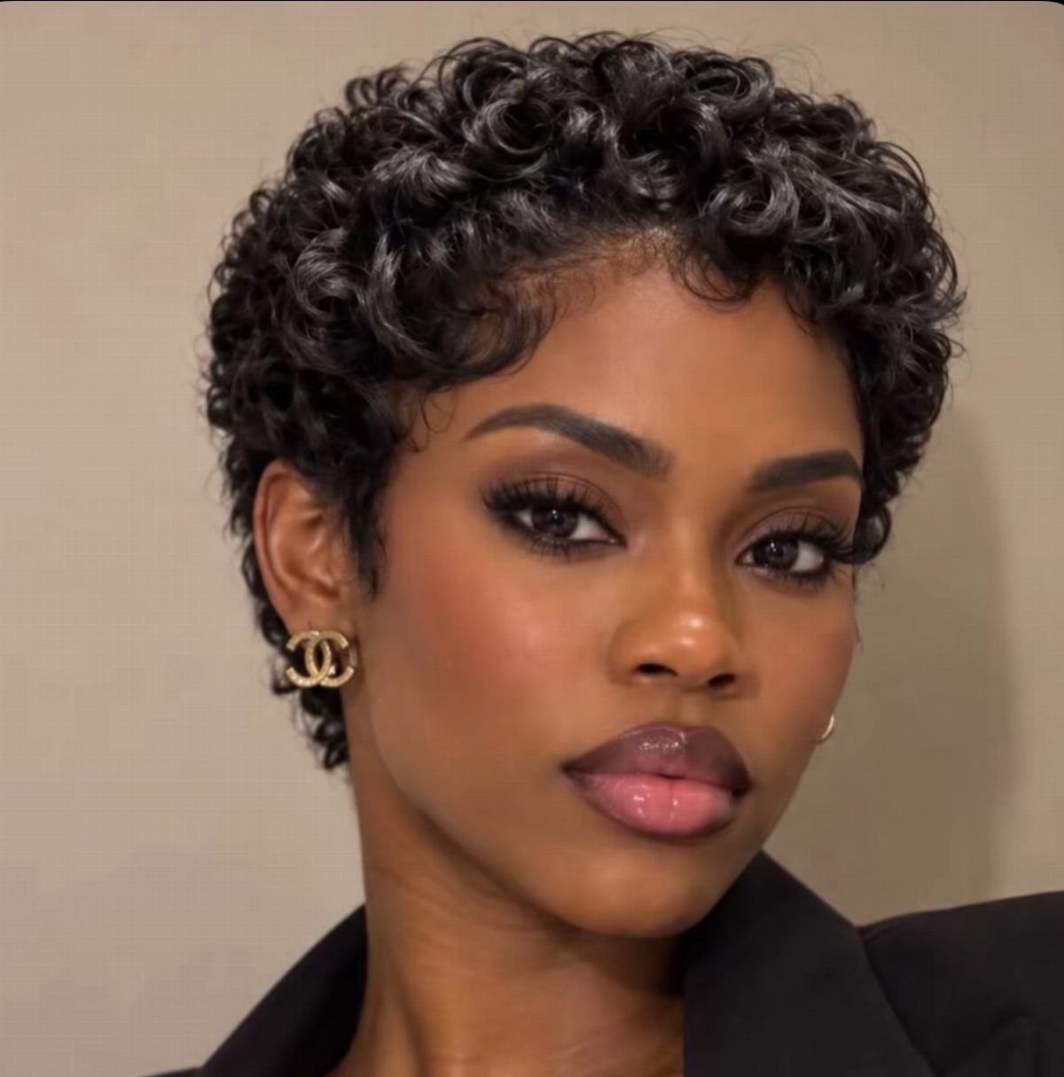 Woman showcasing a short curly Afro pixie haircut with natural volume