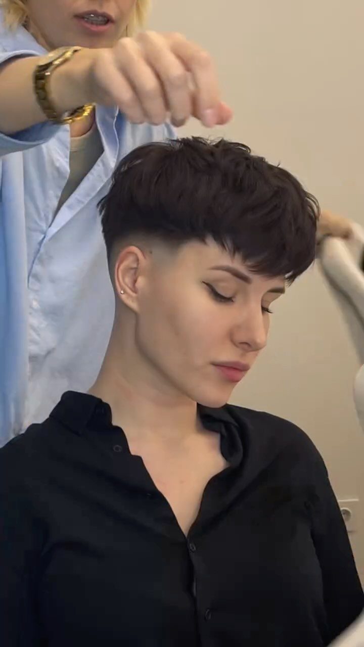 Short dark pixie cut with closely shaved sides and textured top