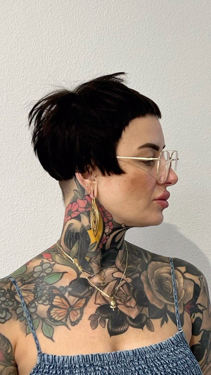 Profile portrait showing a black pixie cut with very short graphic bangs