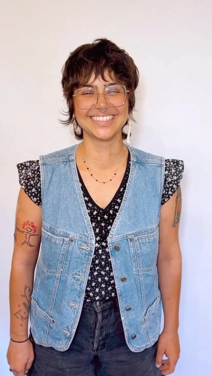 Short dark mullet pixie with tousled baby bangs and longer nape pieces