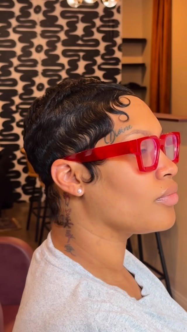 Short dark pixie with sculpted curls along the hairline, styled in a salon