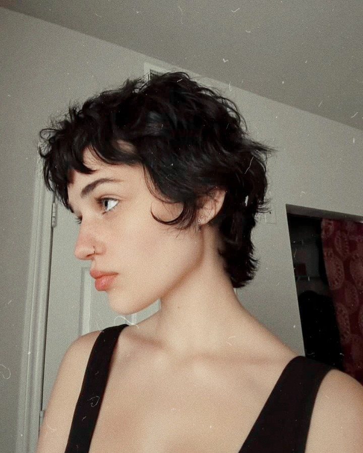 Tousled dark pixie cut with short bangs shown in profile