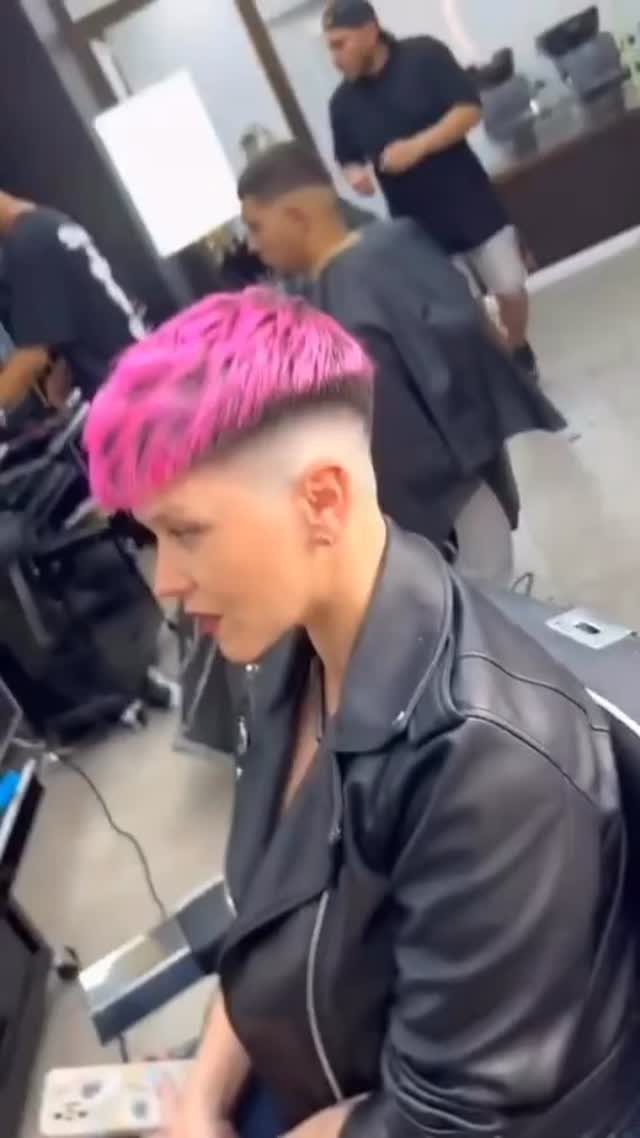Pink-haired person shows a short undercut pixie with closely shaved sides