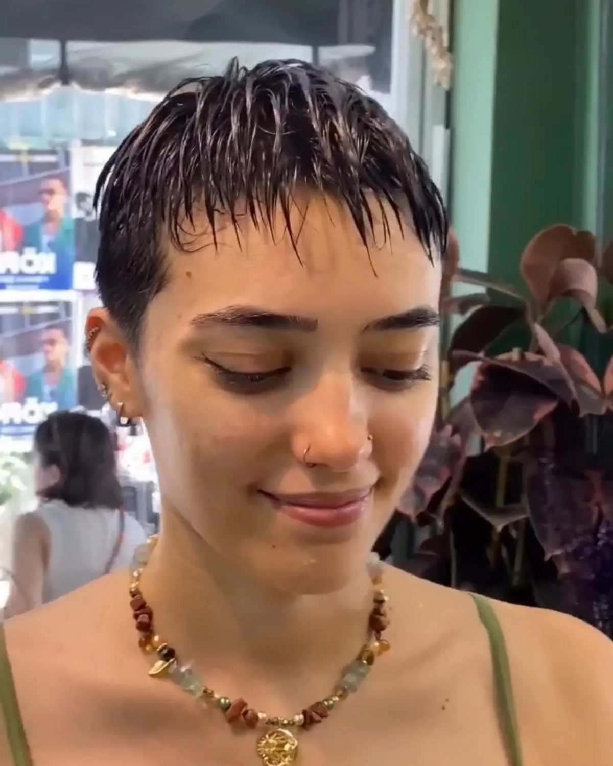 Short dark pixie cut styled with glossy, separated strands and short bangs