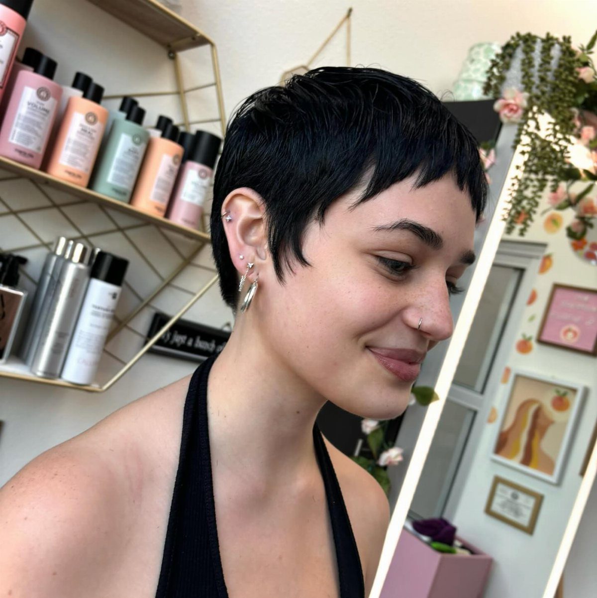 Short black pixie cut with a light, wispy fringe in a salon