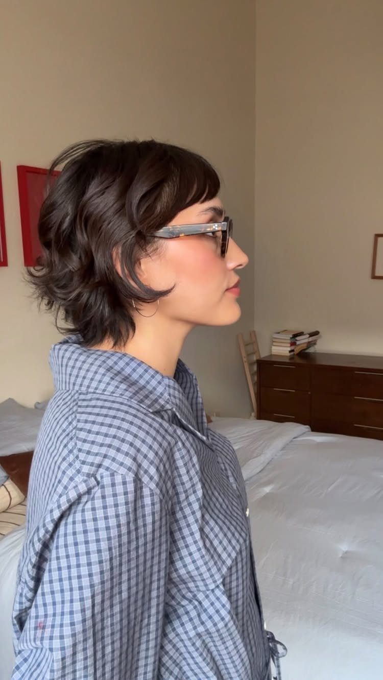 Side profile showing short dark blunt fringe shag haircut with textured layered ends