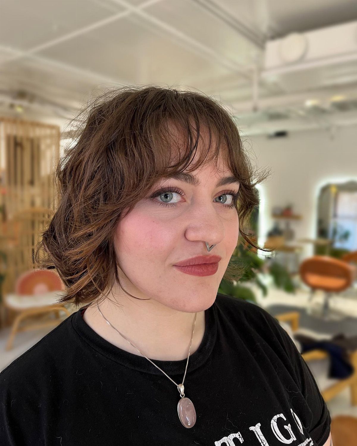 Short brown shag bob with wispy feathered bangs and cheek-framing layers