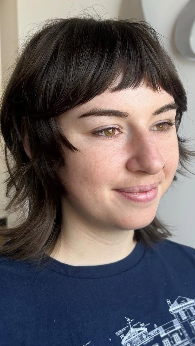 Dark micro shag haircut with short wispy bangs and layered sides