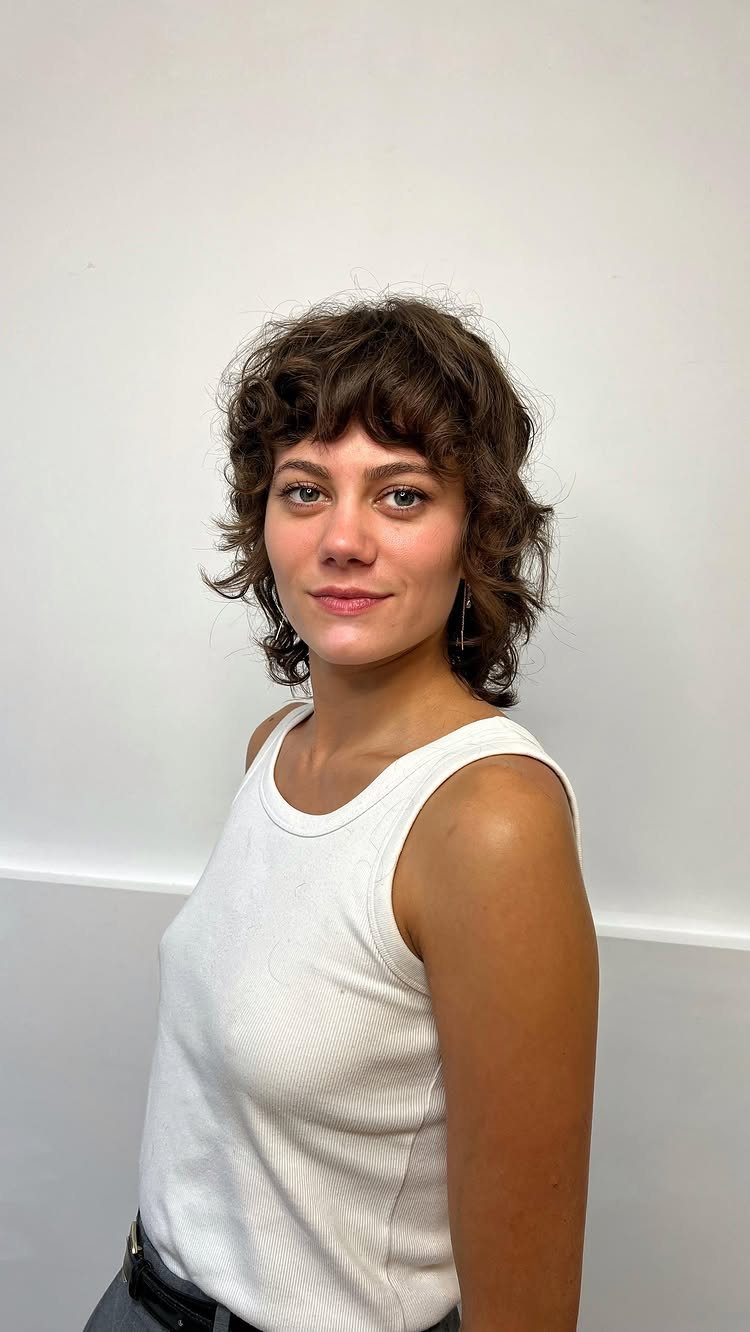 Woman wearing a short, layered shaggy bob with curly bangs