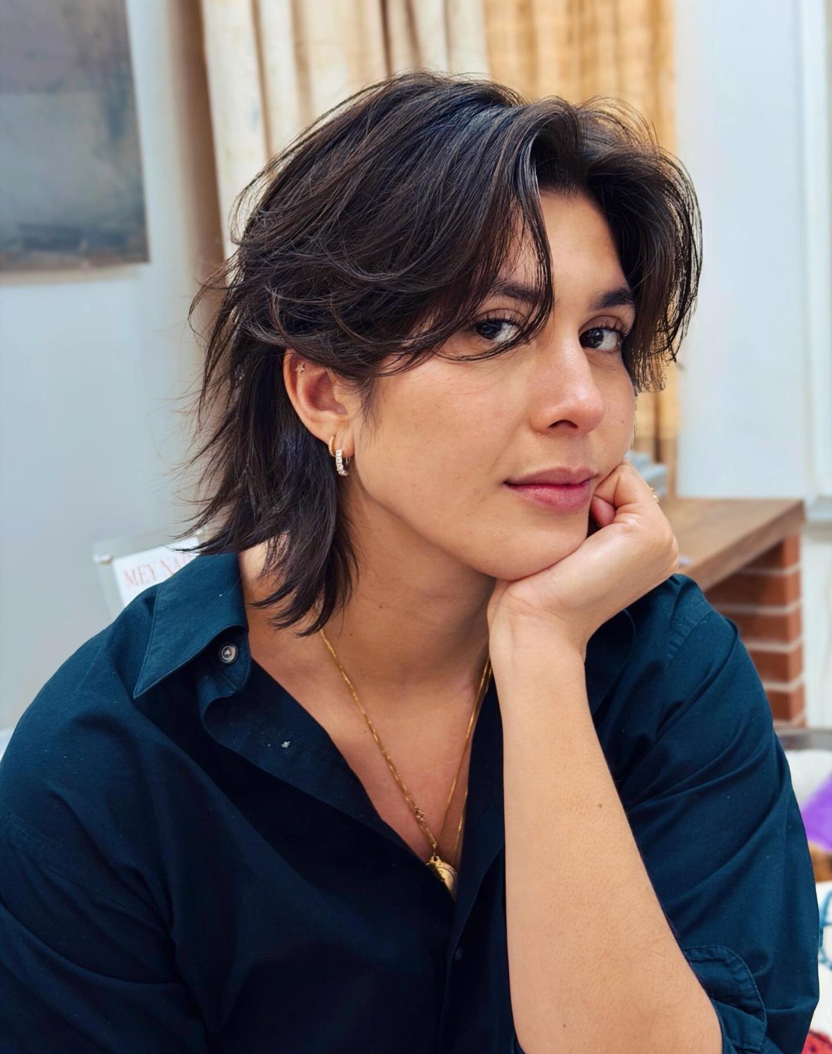 Woman wearing a short textured dark shag haircut with face-framing layers