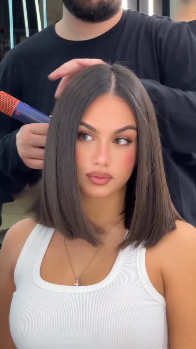 Woman with a straight, center-parted shoulder-length bob and blunt ends