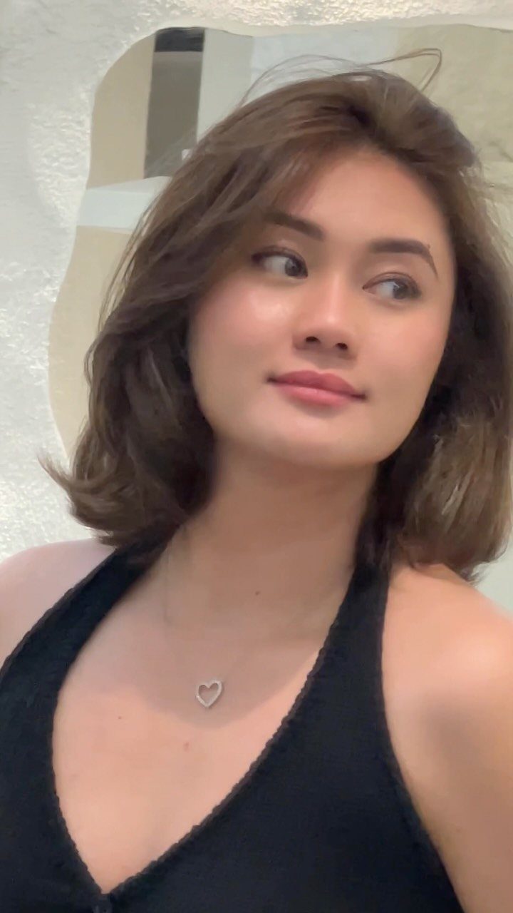 Woman wearing a softly wavy shoulder-length bob with face-framing layers