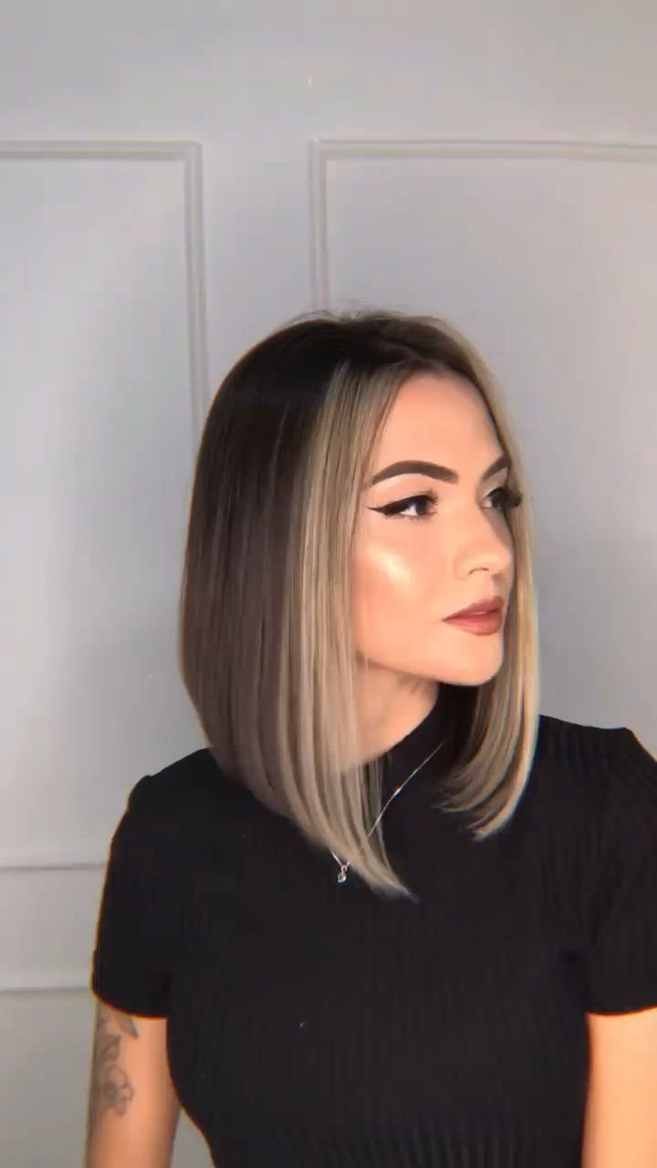 Woman with a sleek shoulder-length bob and blonde highlights wearing a black top