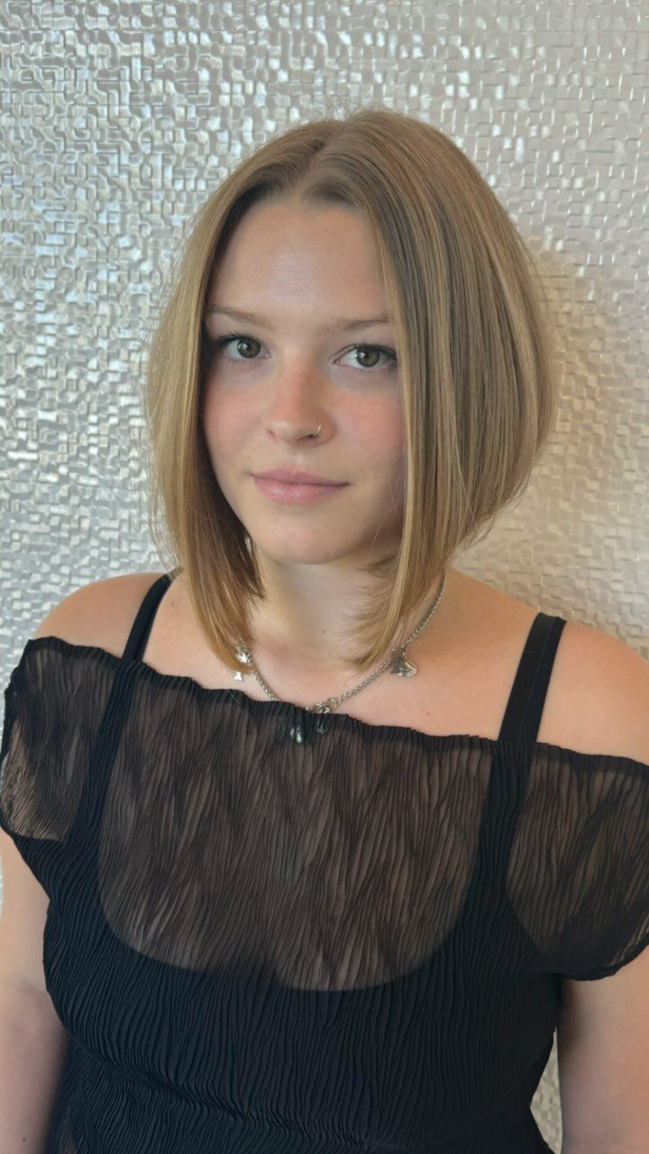 Young woman models a sleek, light-brown A-line bob haircut