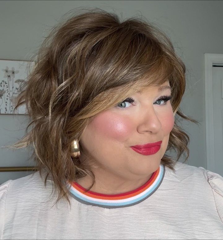 Woman with a tousled, layered brown bob and side-swept fringe