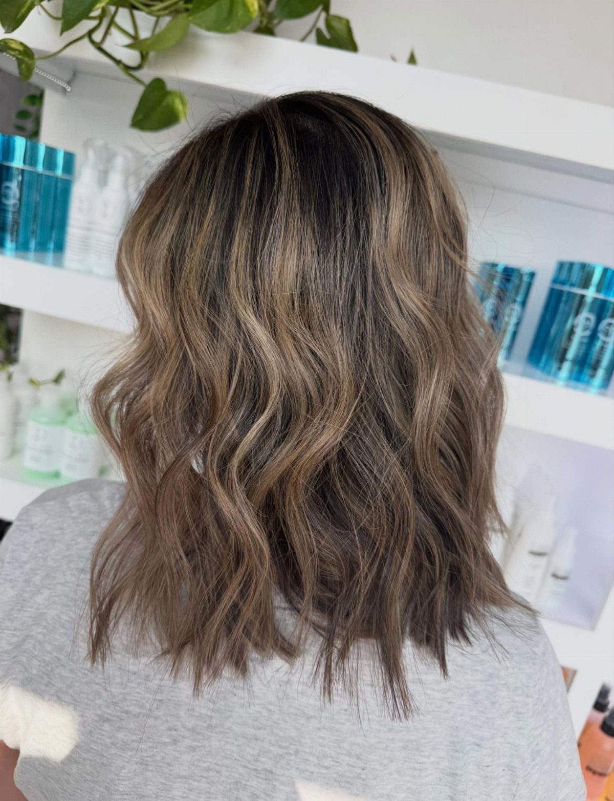 Shoulder-length highlighted brown hair styled in loose, casual beachy waves