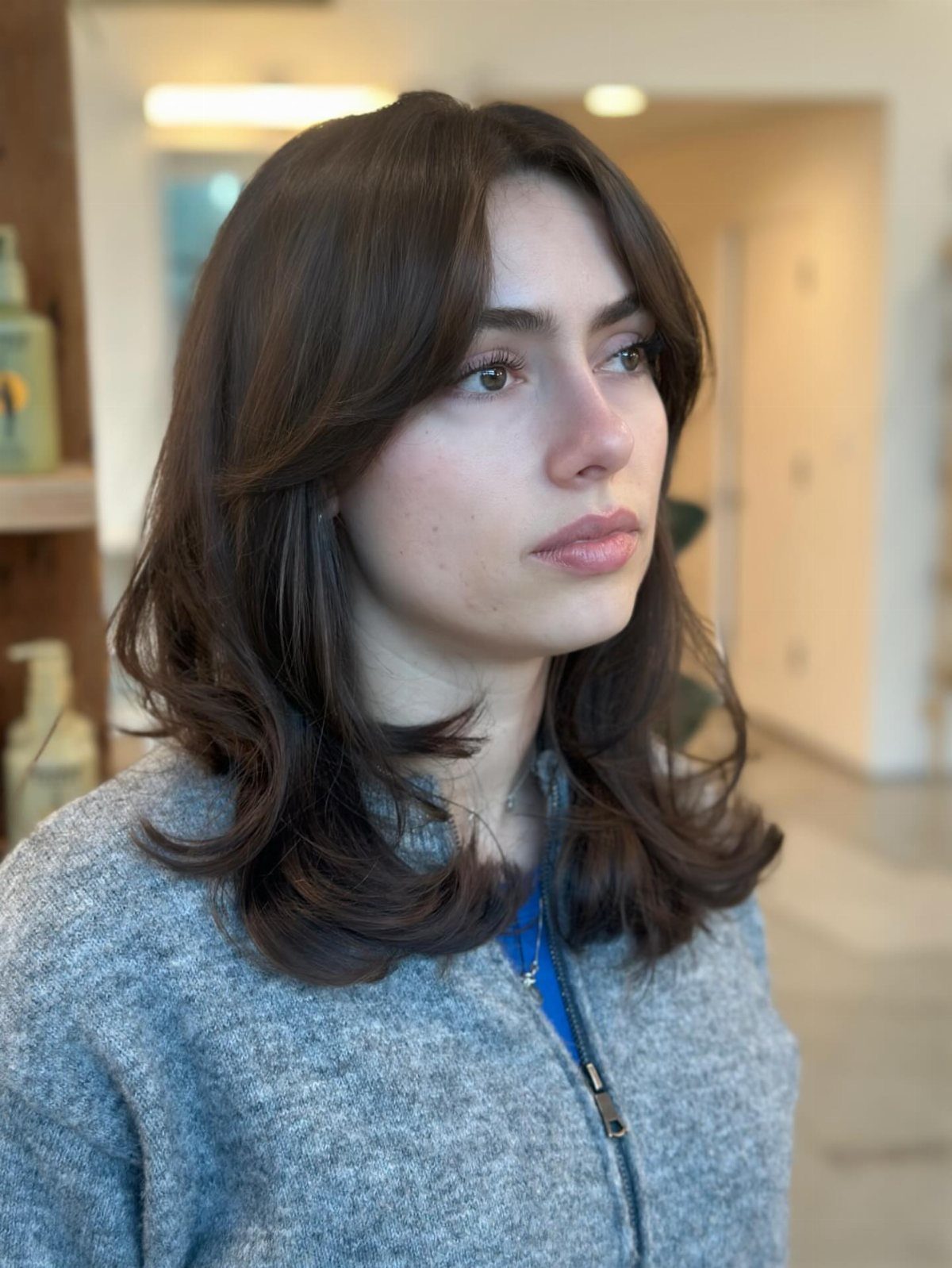 Woman with a smooth, voluminous shoulder-length blowout and curled ends
