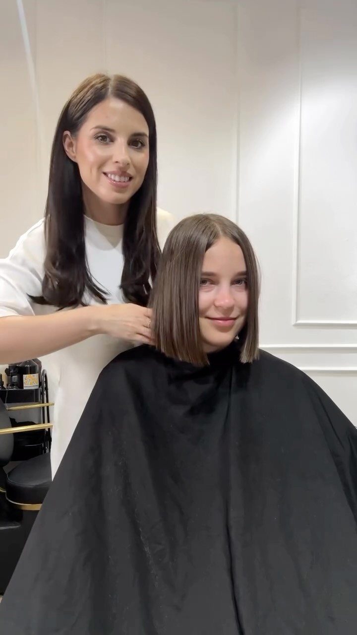 Client showing a straight chin-length blunt bob in a bright hair salon