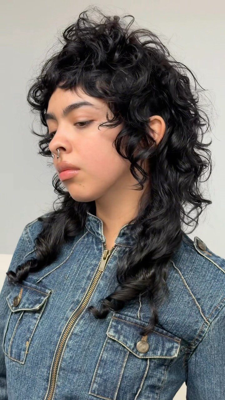 Curly shag with short fringe and layered shoulder-length curls on a person