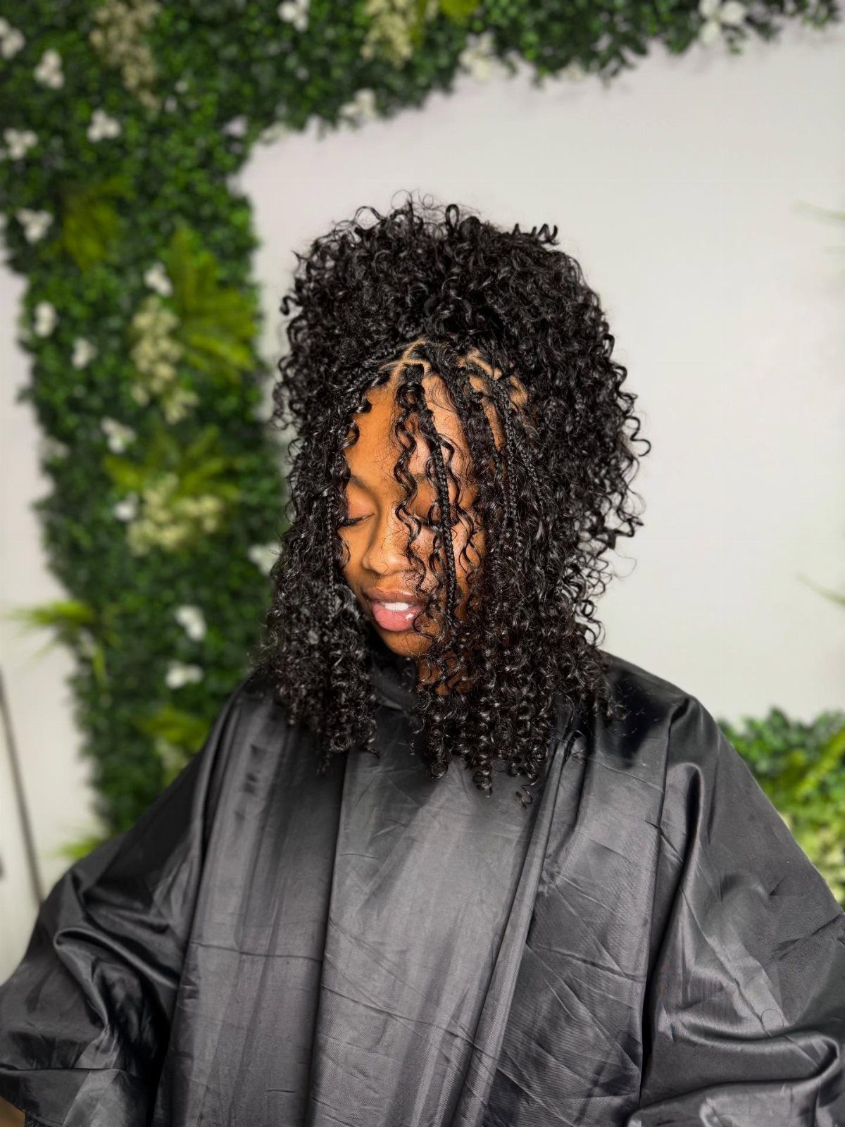Woman displaying full, defined black coils over her shoulders in a salon