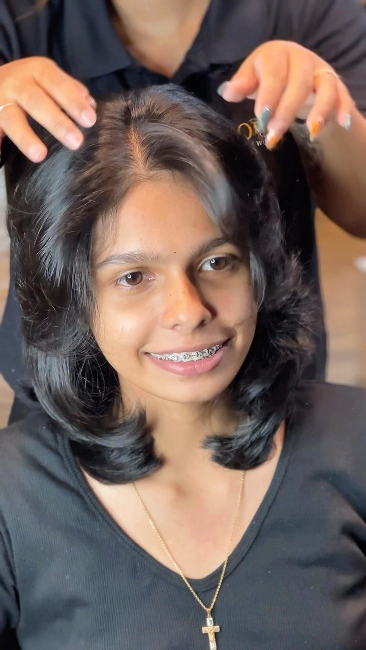 Shoulder-length layered hair with volume and flipped ends in a salon
