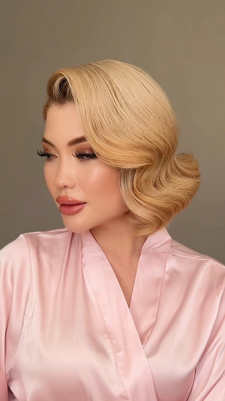 Blonde woman models polished Old Hollywood waves with a deep side part