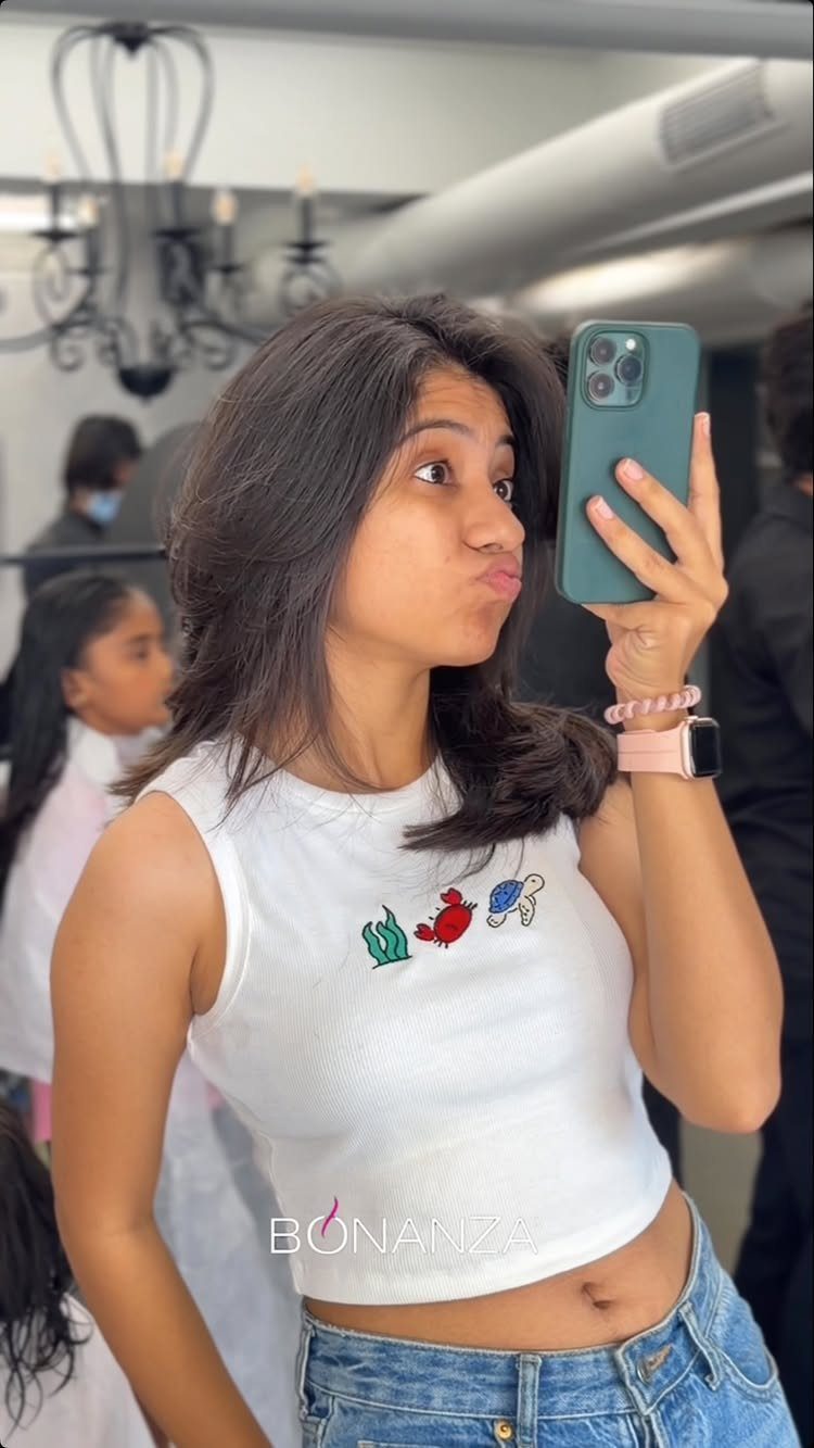 Woman shows shoulder-length layered hair swept across her face