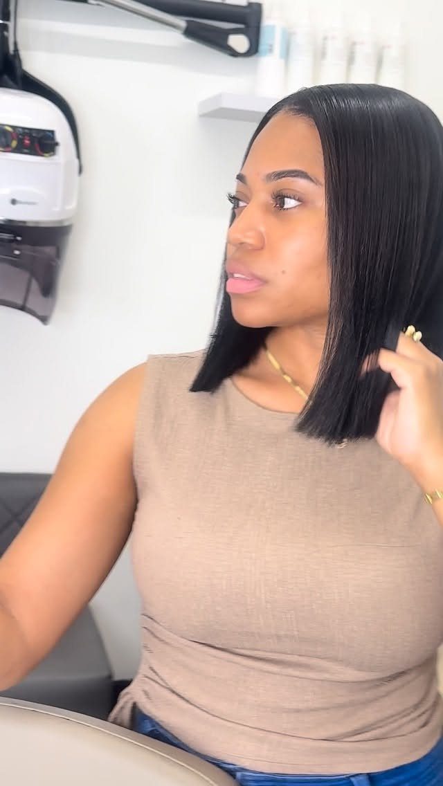 Woman with smooth, straight shoulder-length black hair in a salon