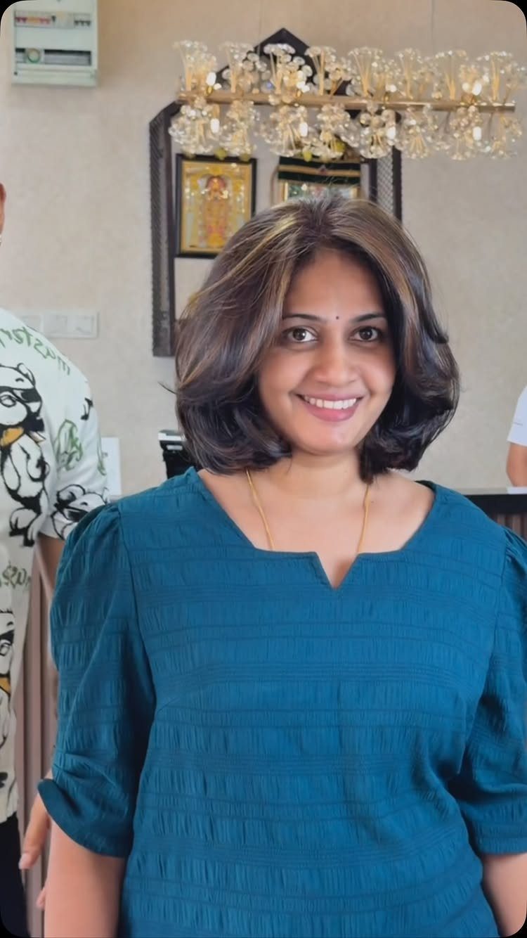 Woman with shoulder-length dark hair styled in loose, soft bends