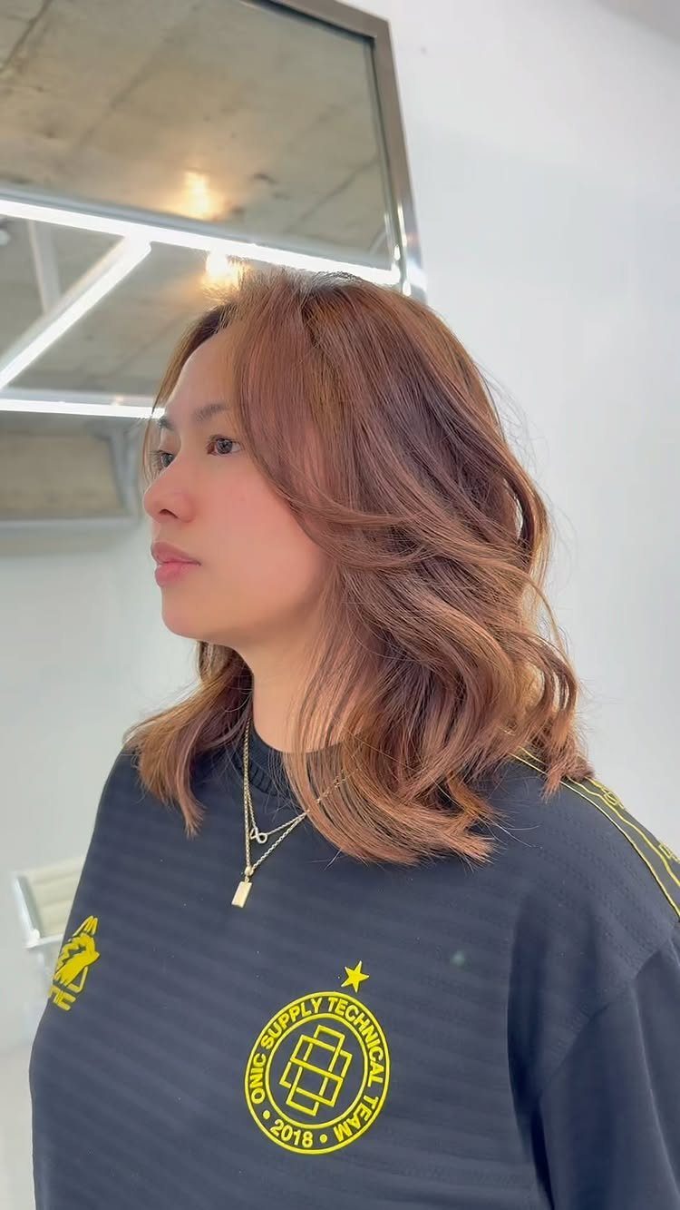 Shoulder-length auburn hair styled in loose, textured layers with soft waves