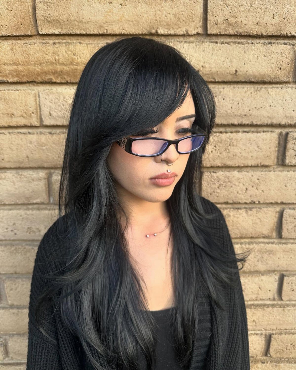 Long black hair with sleek side-swept bangs framing a person's face