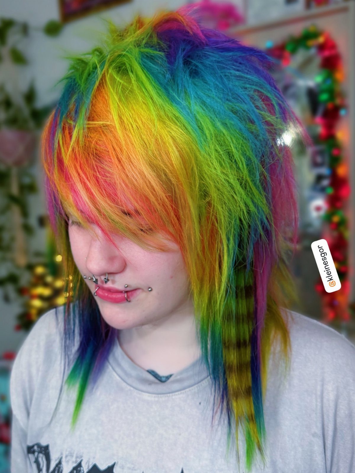 Rainbow-haired person with multicolored angled fringe swept across the face