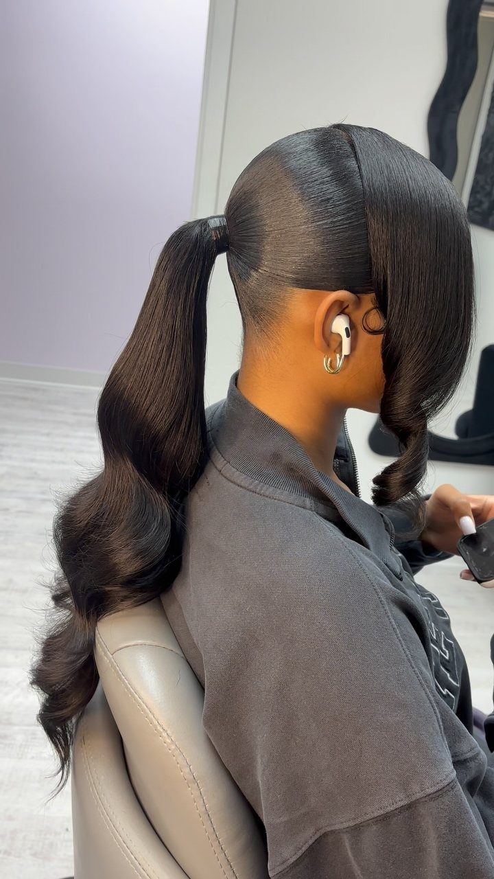High ponytail with long side-swept bangs and curled ends