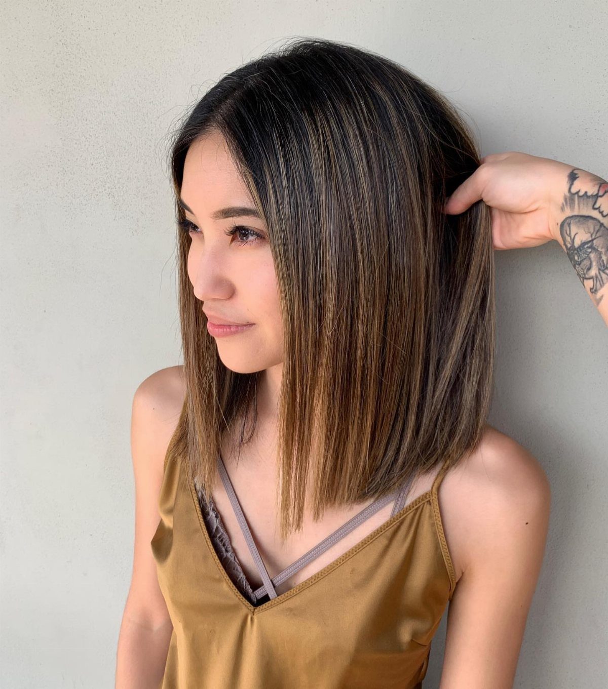 Woman showing a straight highlighted lob with a center part