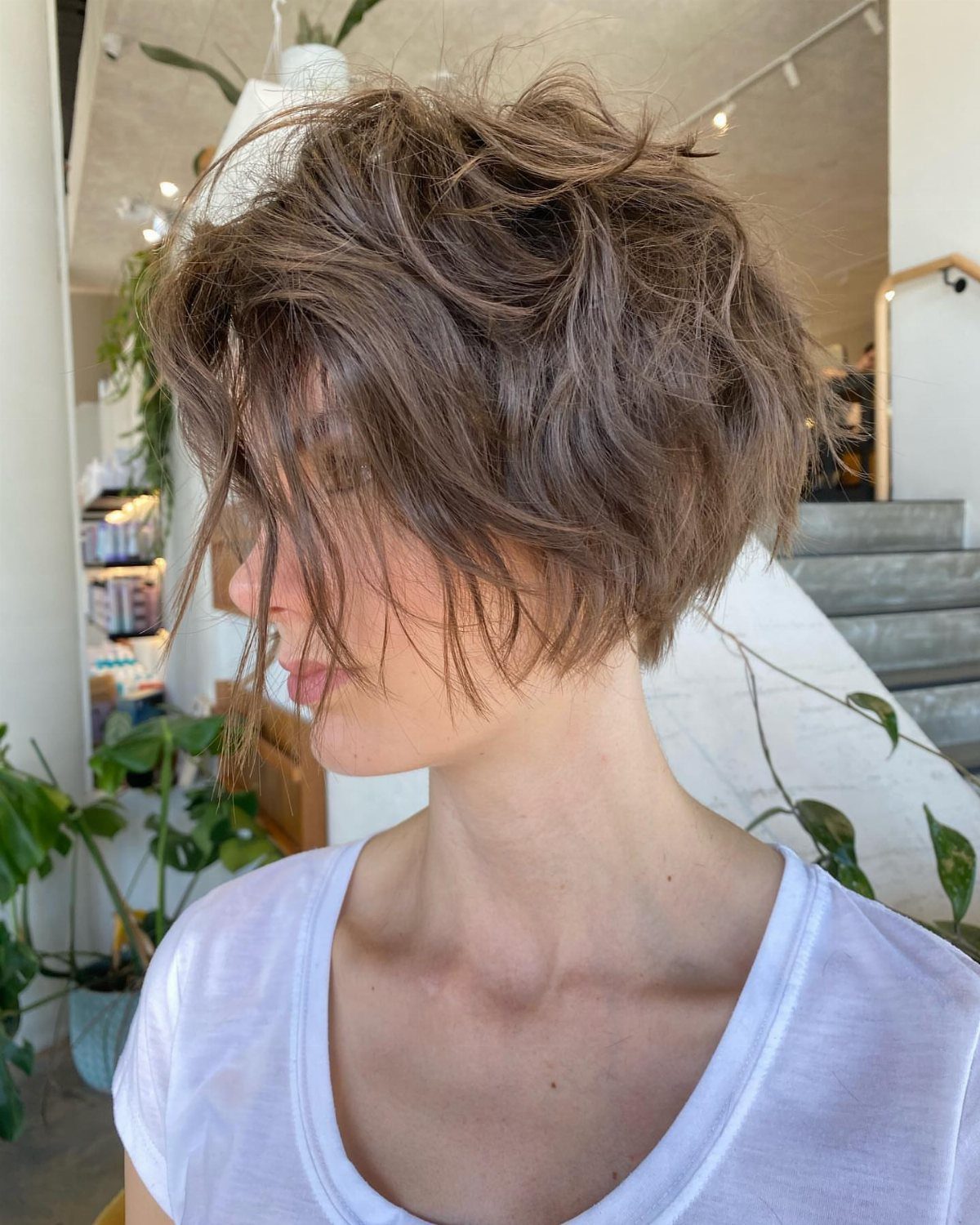 Medium-length tousled brown crop with layered texture and long fringe