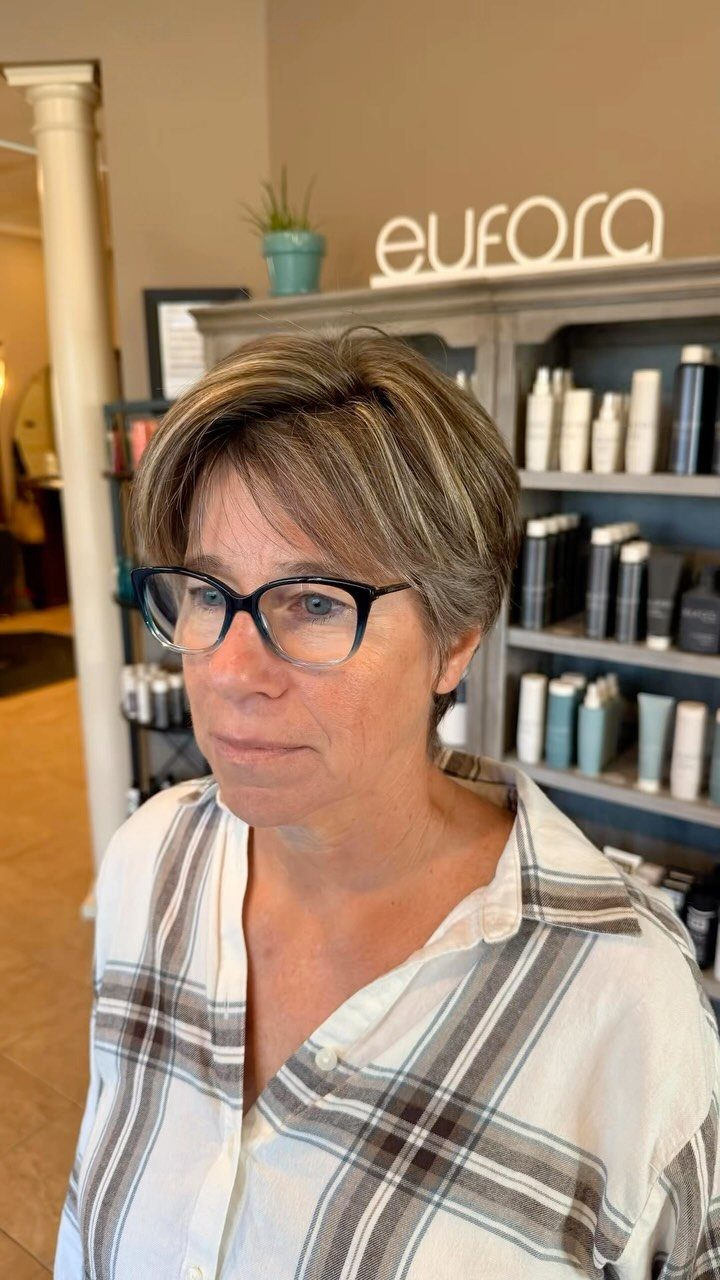 Woman with layered brown crop haircut and longer side-swept fringe in a salon