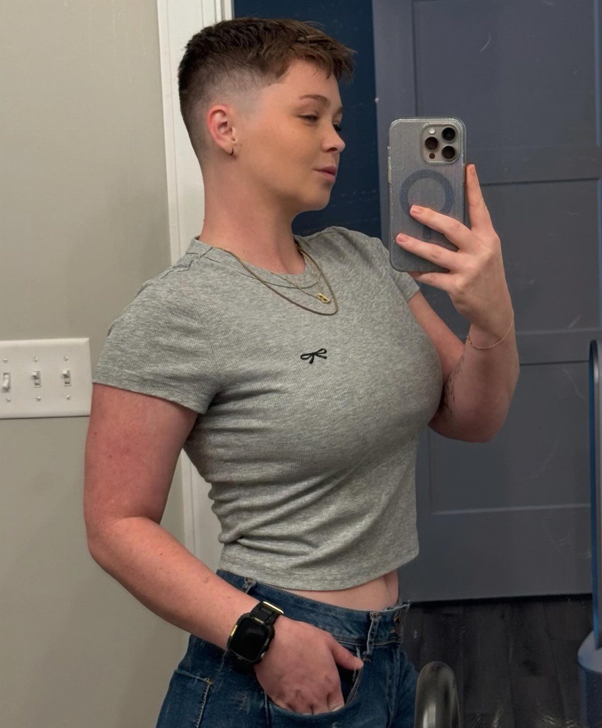 Short brown textured crop with a low fade shown in a bathroom mirror selfie