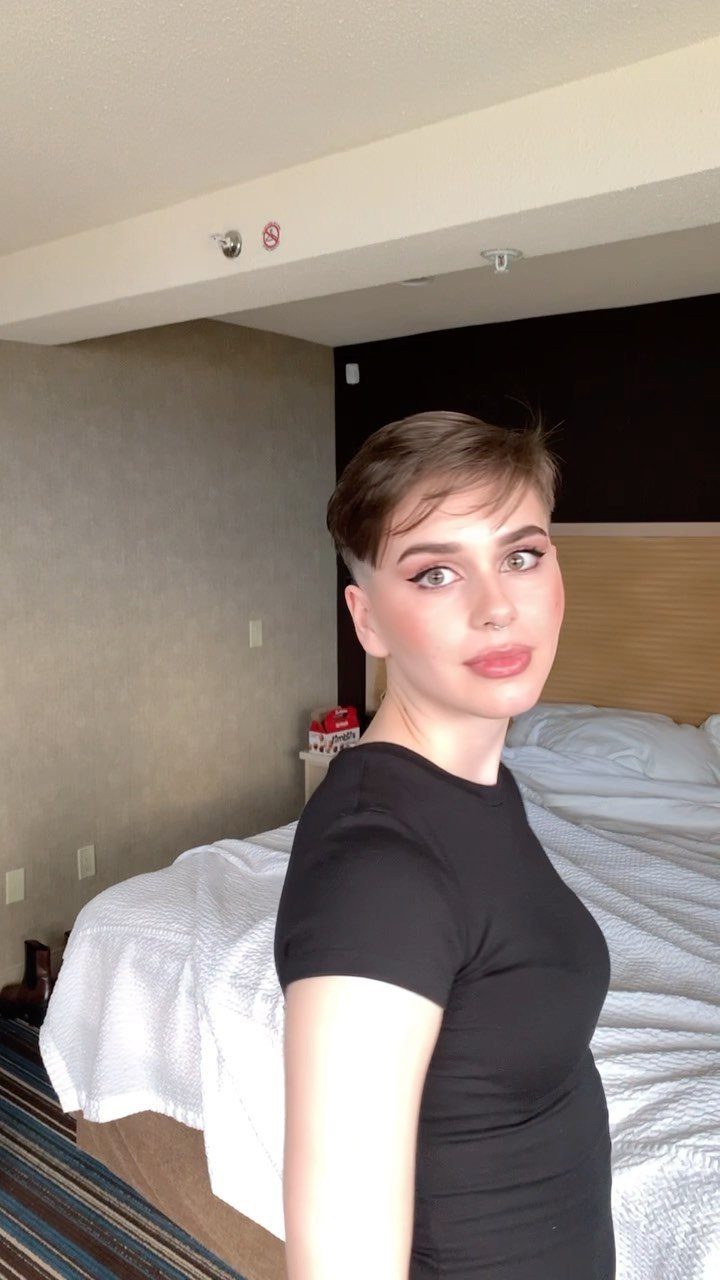 Young person showing a short, textured brown crop haircut with a side-swept fringe