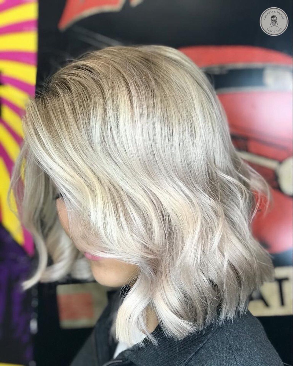Blonde long bob styled in loose waves with layered ends