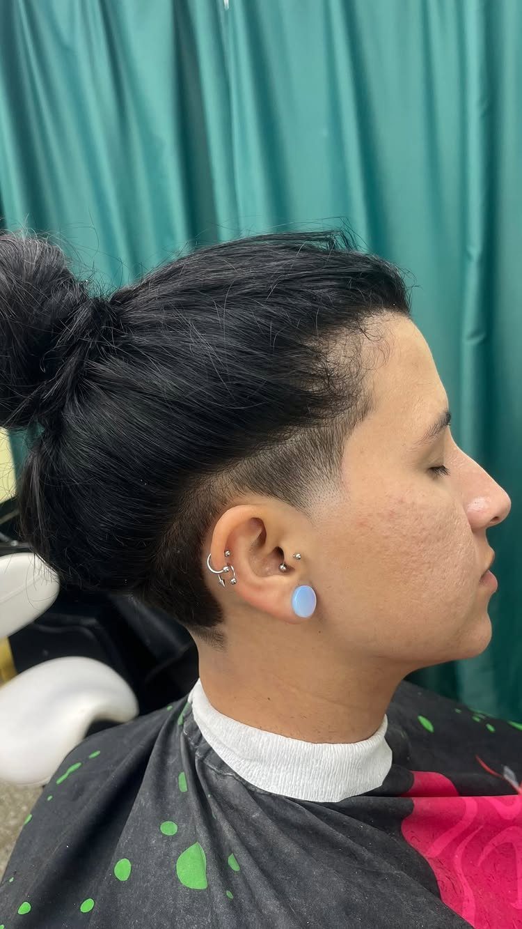 Two block haircut with long top hair tied back and closely shaved sides